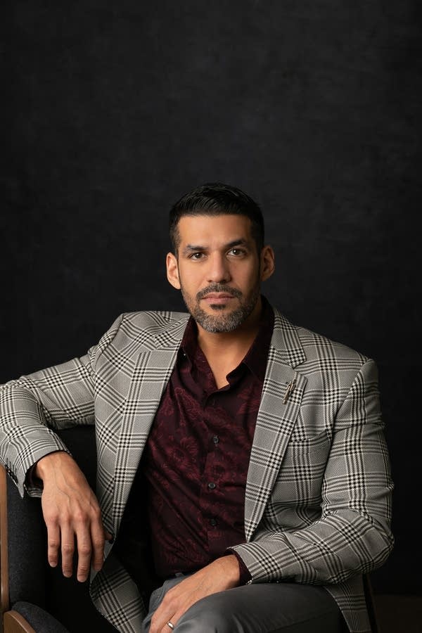 A man in stylish clothing poses for a portrait