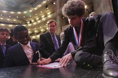 A pianist signs autographs following an awards ceremony