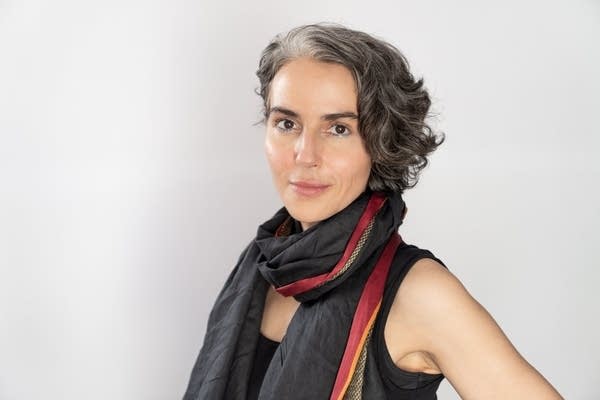 A woman in stylish clothing poses for a portrait