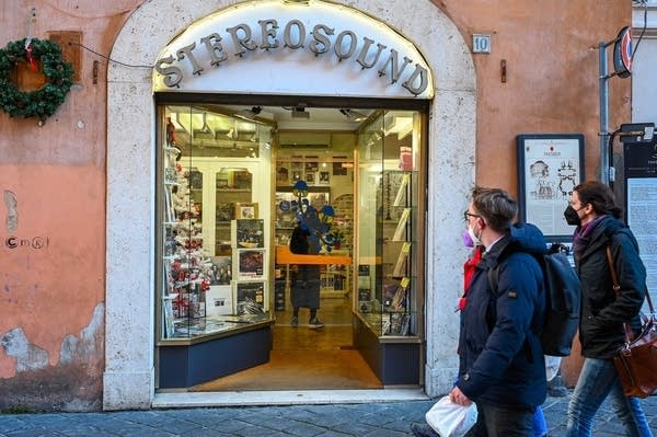 People walk past the entrance to a record shop in Rome